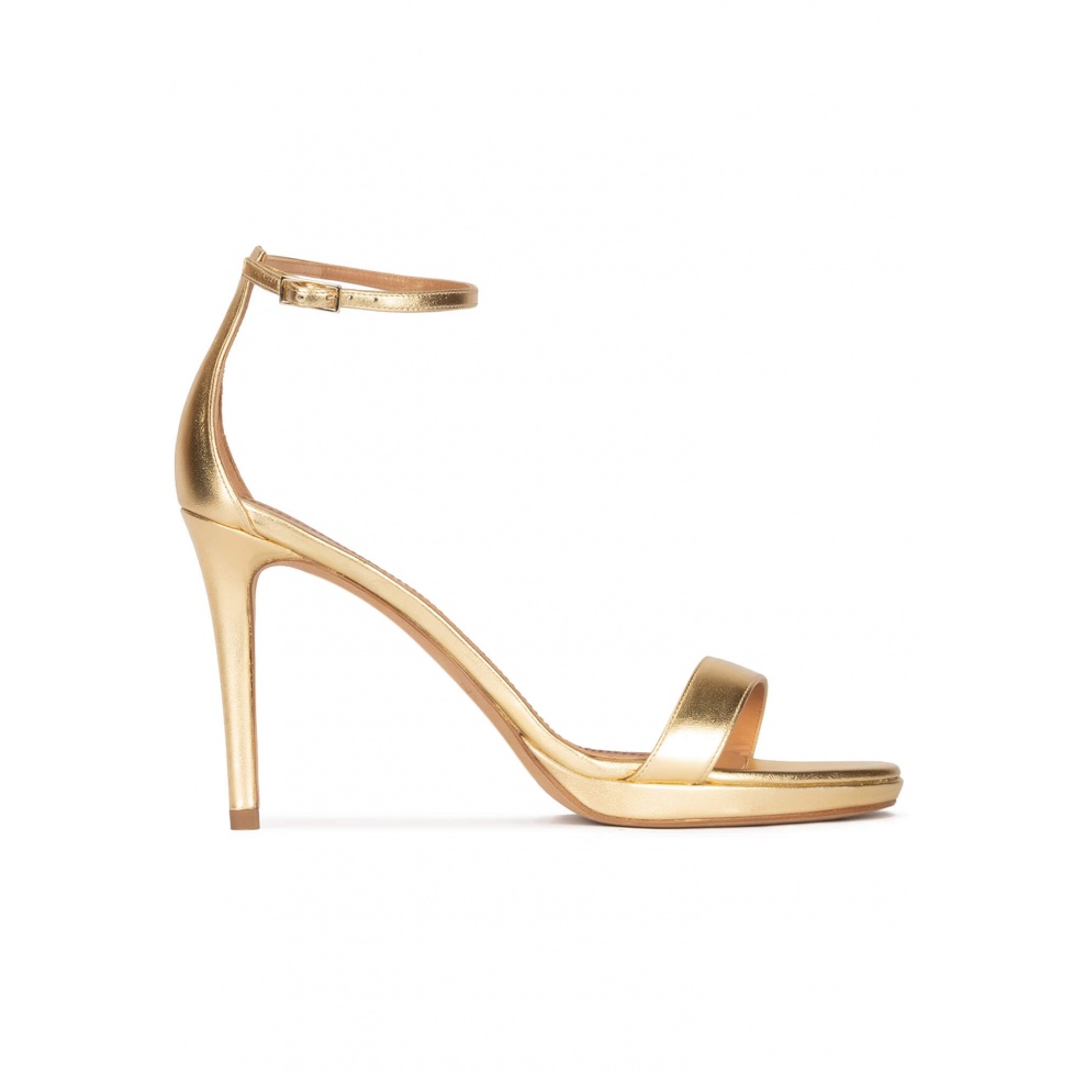 pura lópez Sandalias doradas de plataforma y tacón alto en piel con pulsera